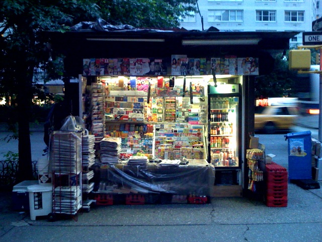 a food stand with magazines and boxes on it