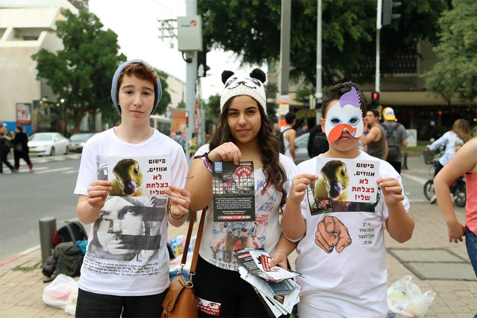 three young people with fake faces on their face and some posters taped to them