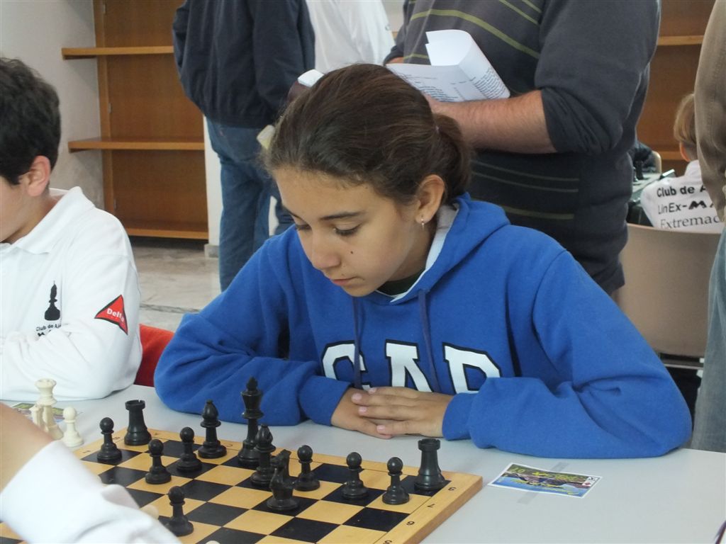 a small child sitting in front of a chess board