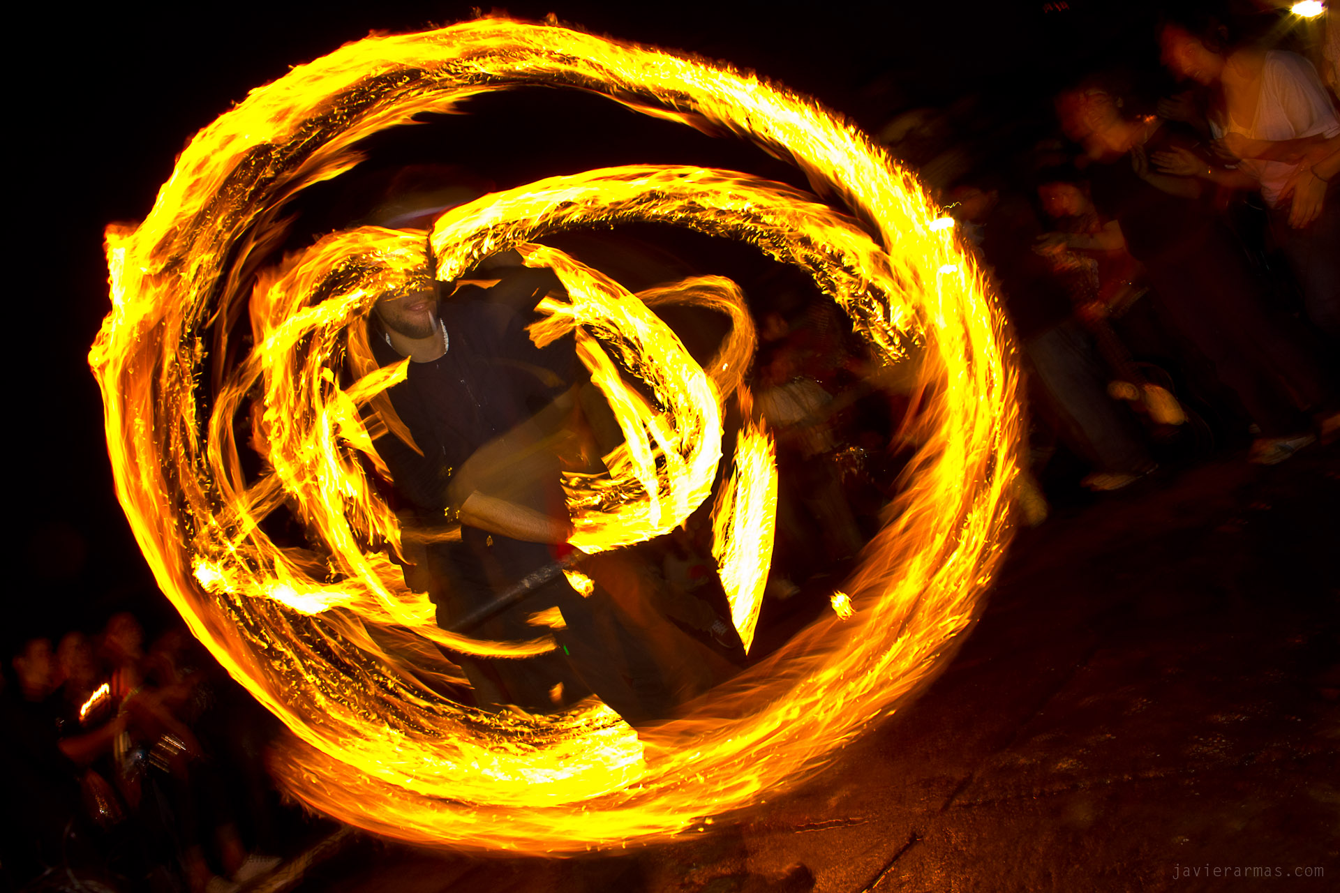 fire spinning at night showing flames in the air