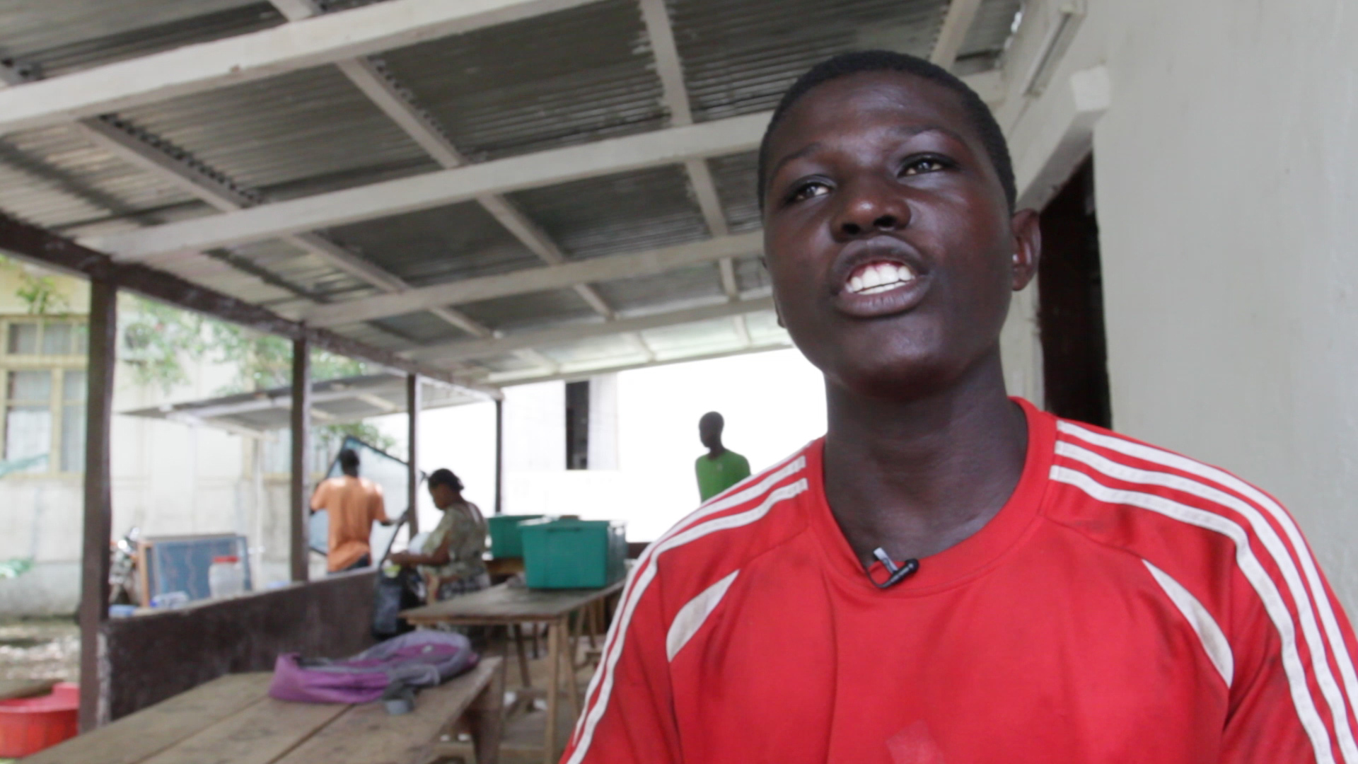 a young man smiling for the camera with people around him