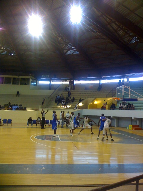 players are playing basketball in an indoor gym