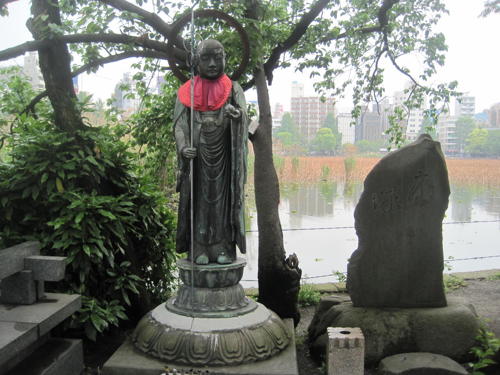 a statue in the foreground with a pond in the background