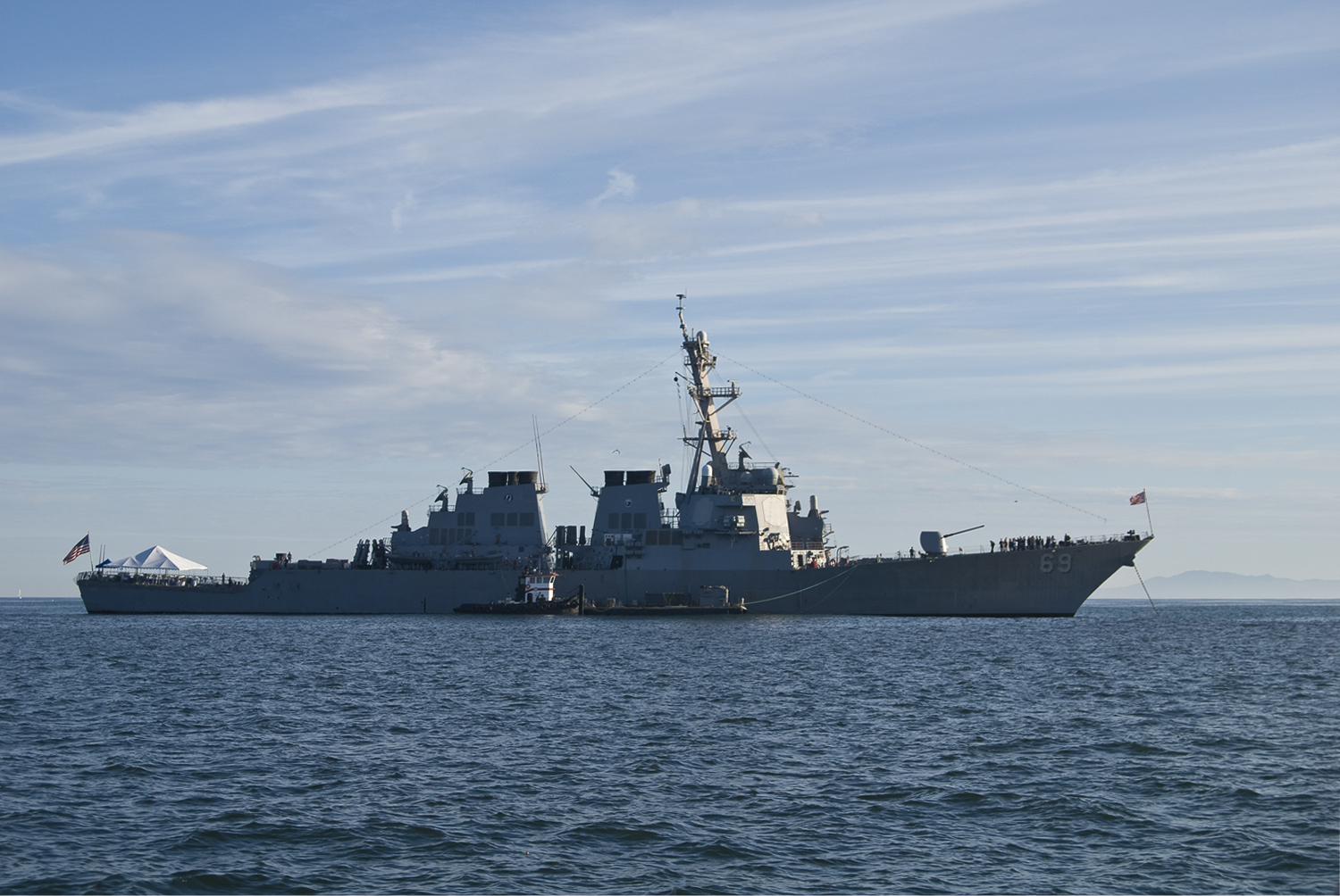 a navy ship is traveling on the water