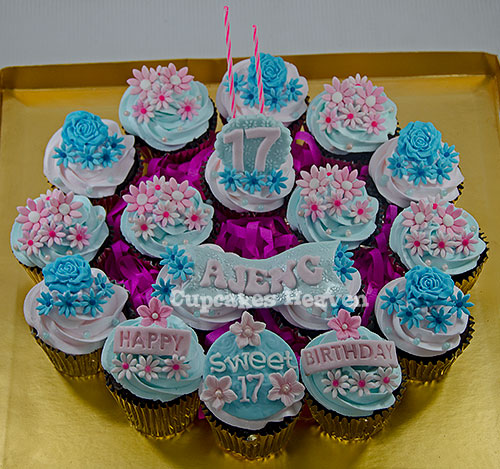 cupcakes with colorful frosting and frosting decorations in the shape of flowers and candles