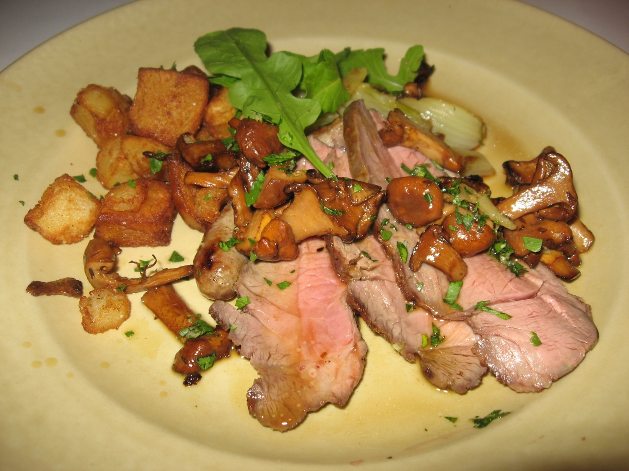 a plate with meat, potatoes and greens on it