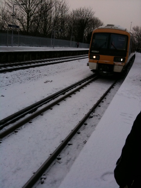 a train coming down the tracks covered in snow