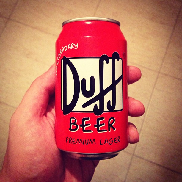 a hand holding a can of duffel beer