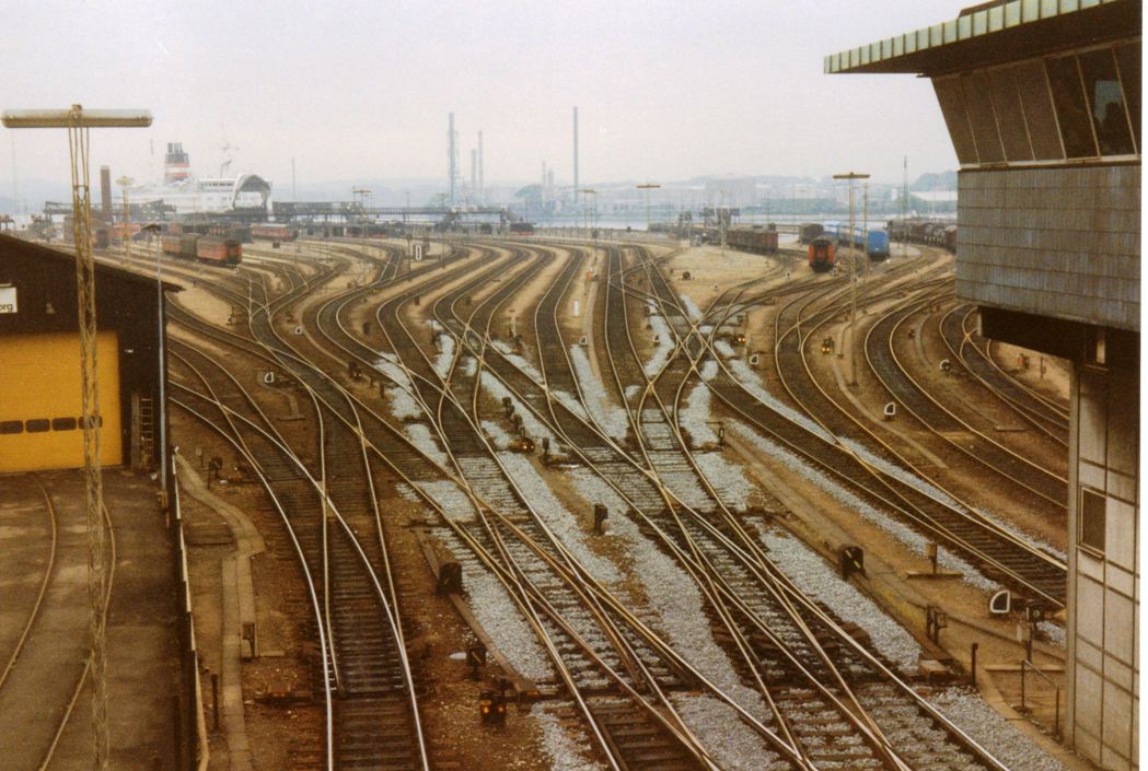 some railroad tracks are empty and full of cars