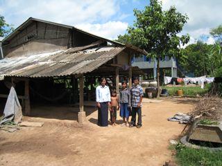 three men standing in front of a shack