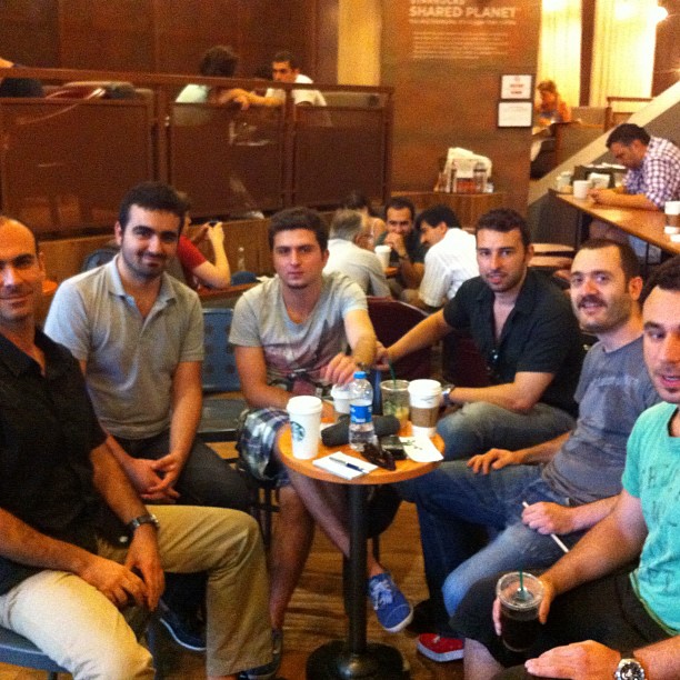 men and women sitting together around the table in a restaurant