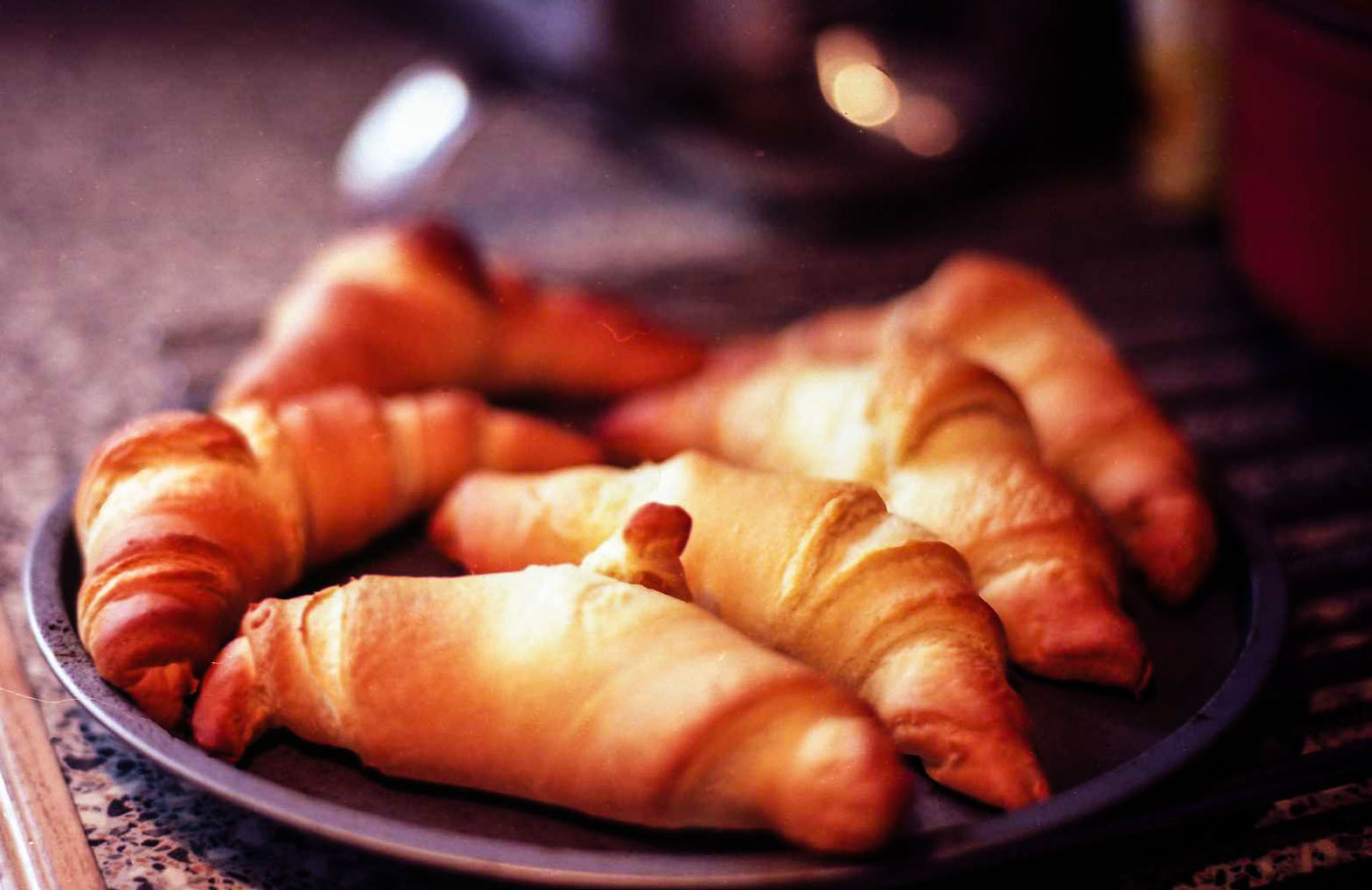 fresh croissants are on a plate on the counter