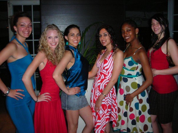 many women pose for a po in evening dresses