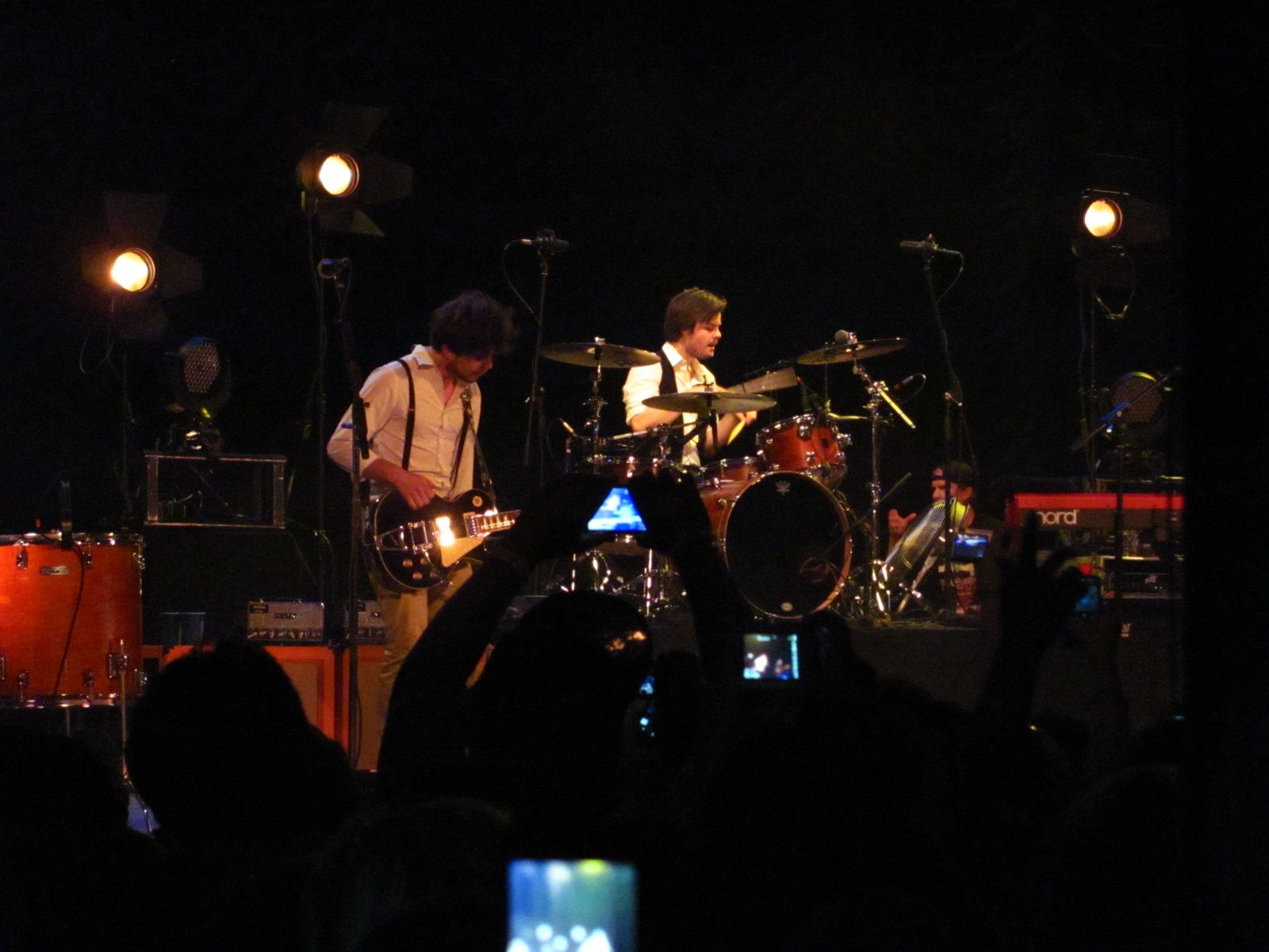 a man plays a guitar while a band performs on stage