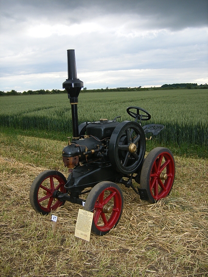 a small tractor in a field with grass