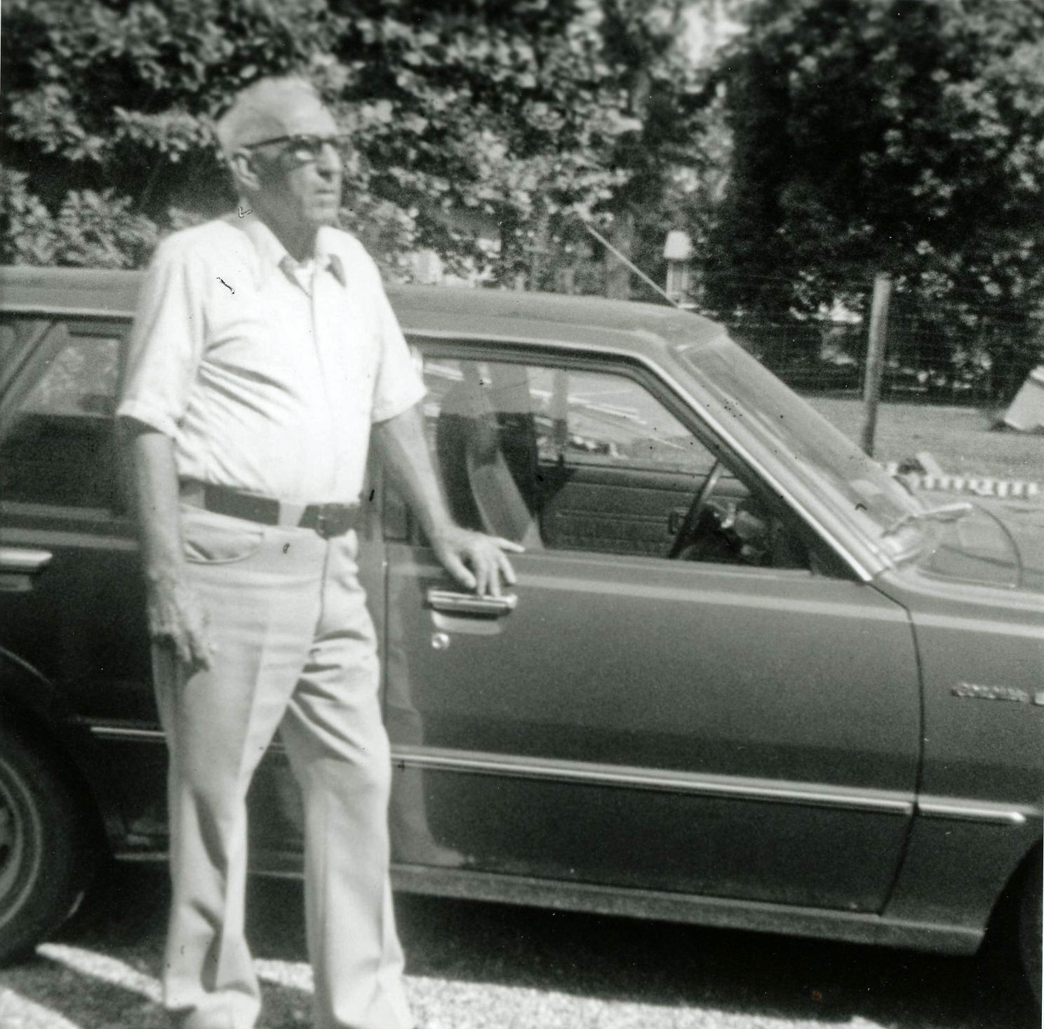 a man standing next to a parked car