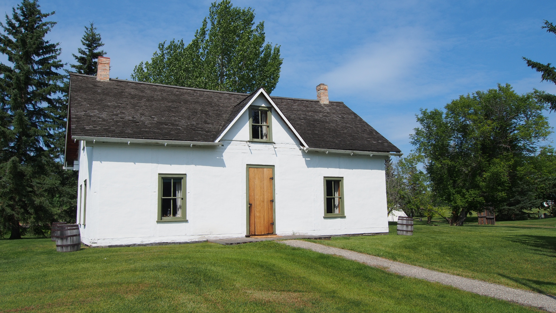 an old white two story house with green grass