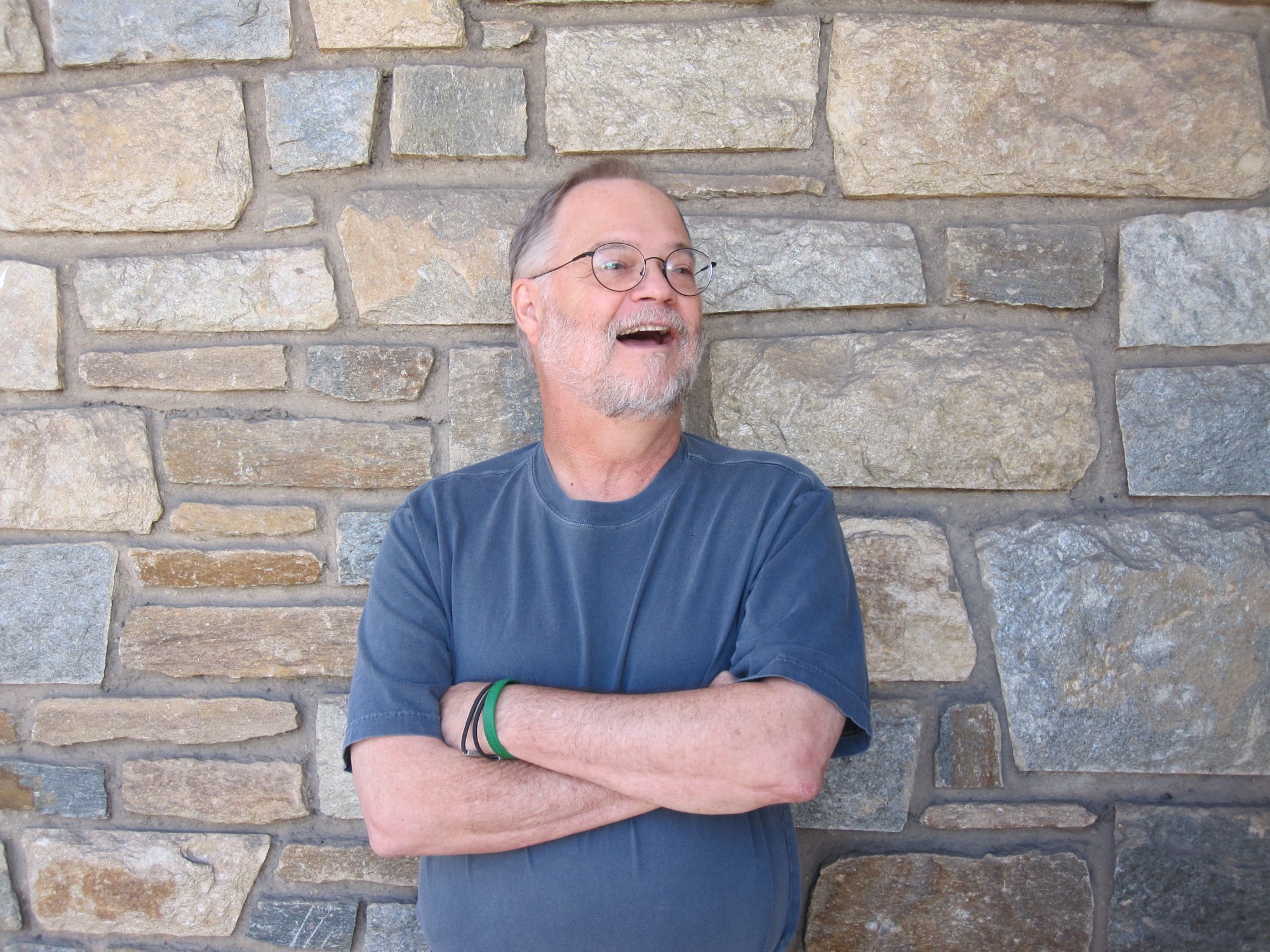 an older man is standing with his arms crossed