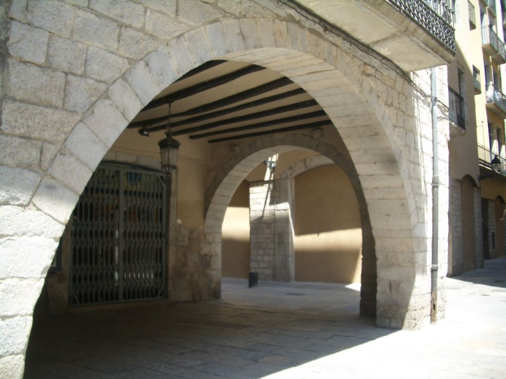 an alley way with arched concrete walls and doors