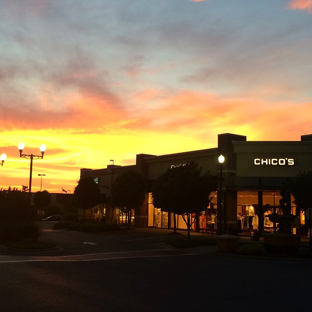 a sunset over a small building in the city