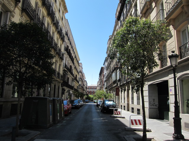 a quiet street in an european city with tall buildings