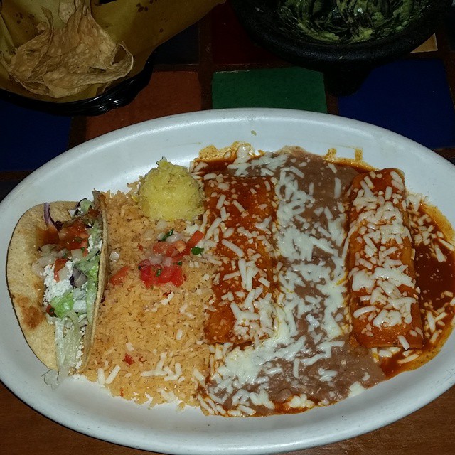 a plate with a burrito, rice and salsa