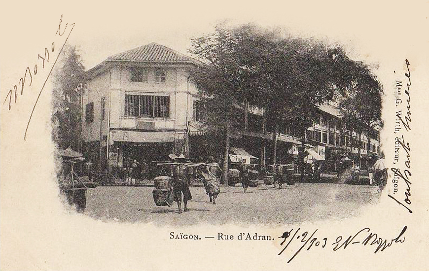 an old picture of people on the street in front of houses