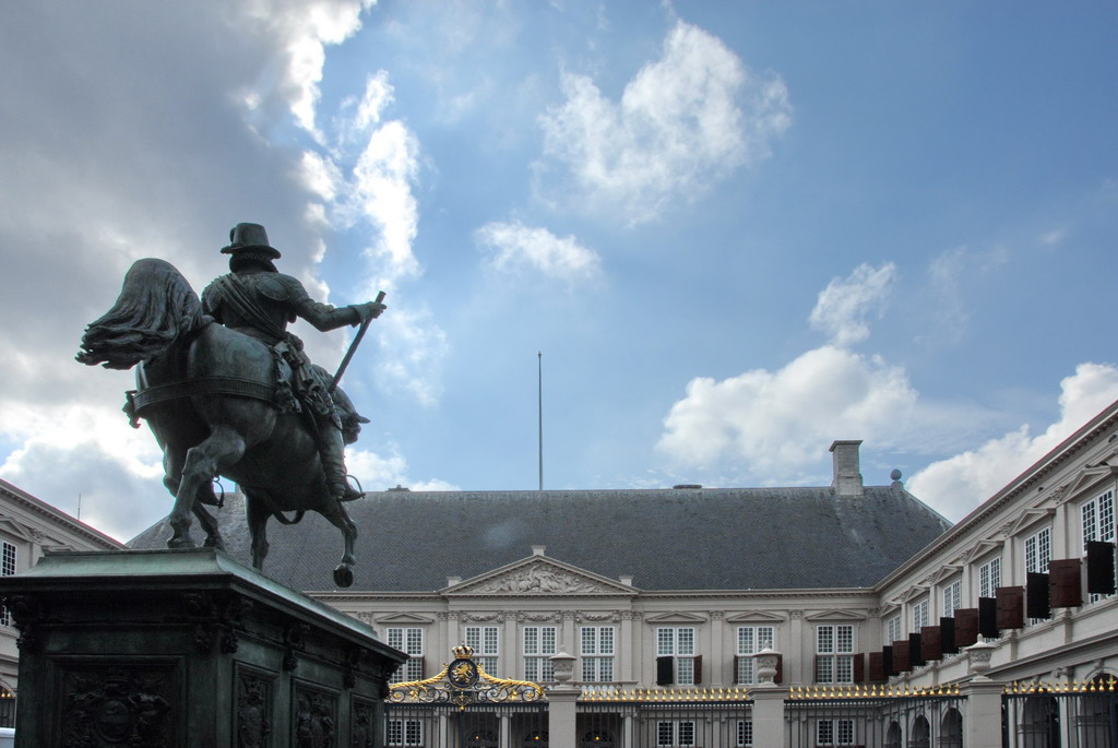 statue of man riding a horse in front of large white building