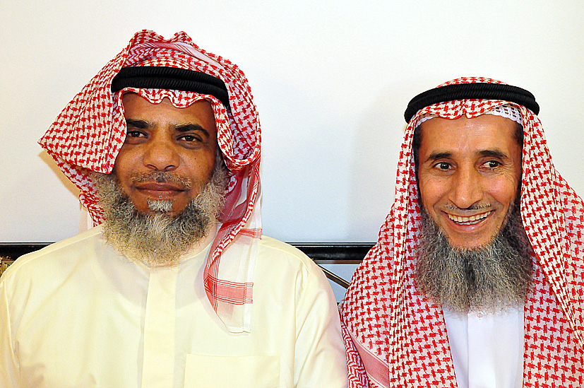 two smiling young men wearing red and white attire