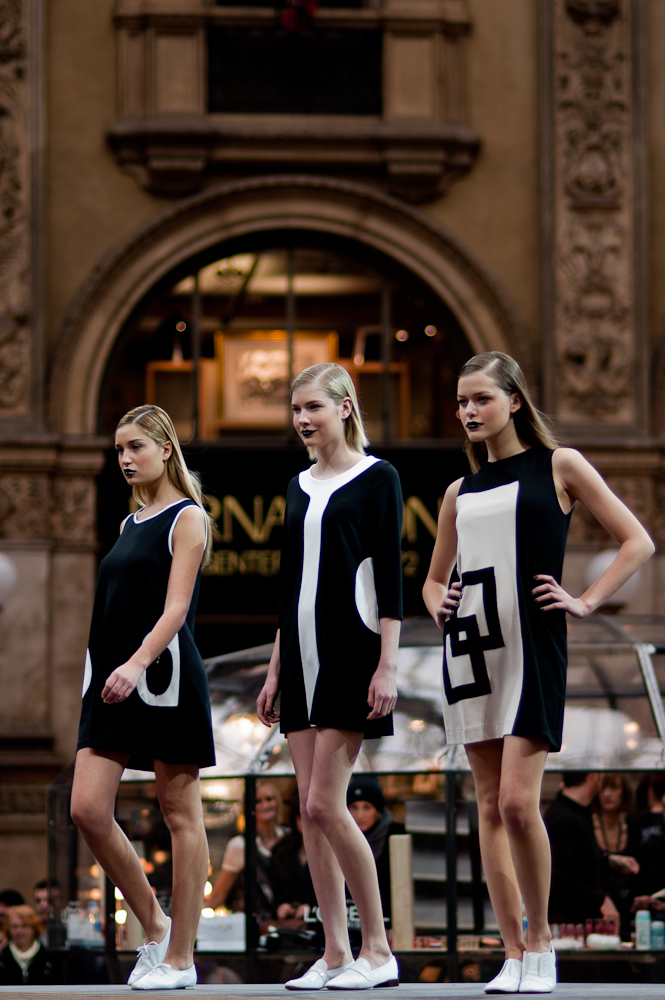 four models in black and white outfits walking down a street