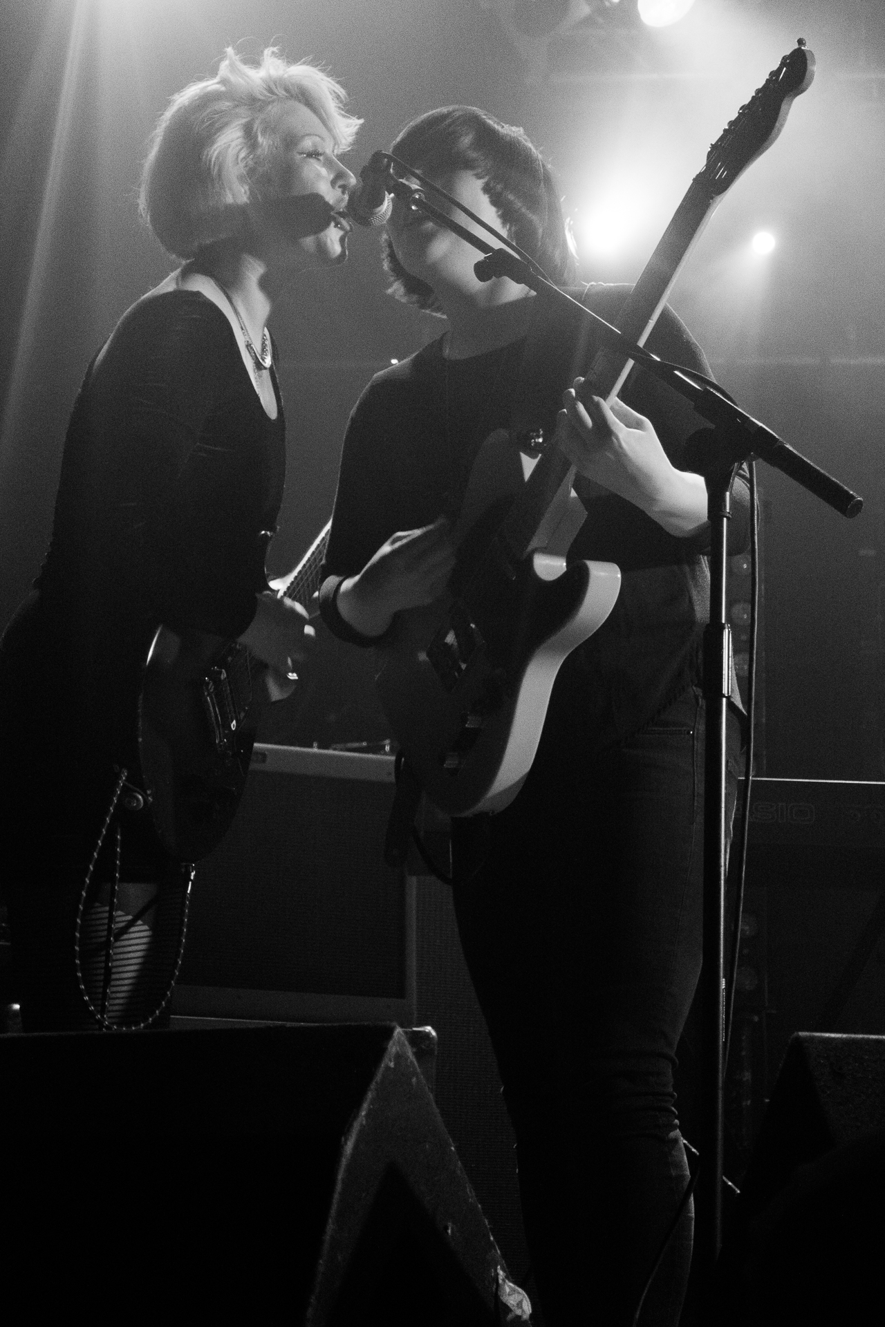 two woman on stage one holding a guitar