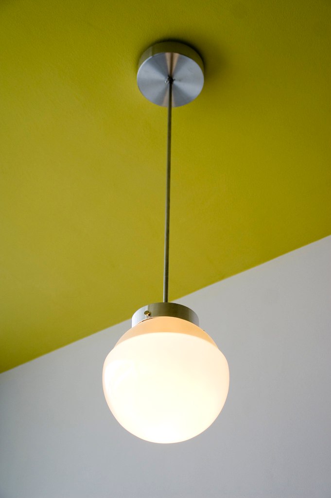 a lamp hanging from the ceiling near a wall