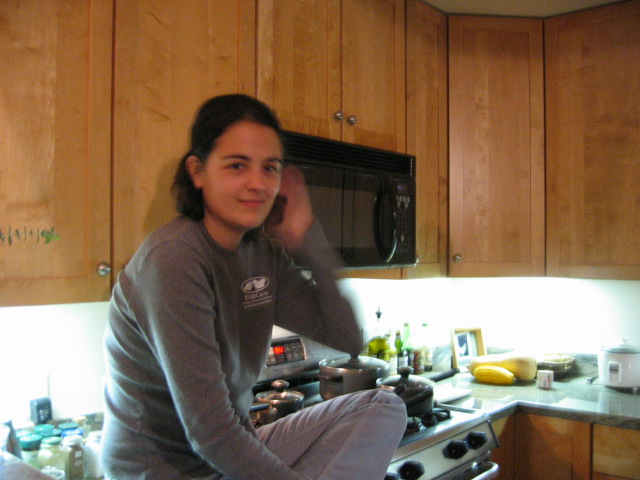 there is a young woman sitting on top of the oven