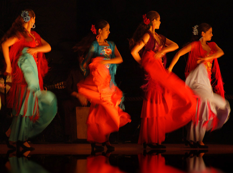 a group of women dancing in colorful dresses