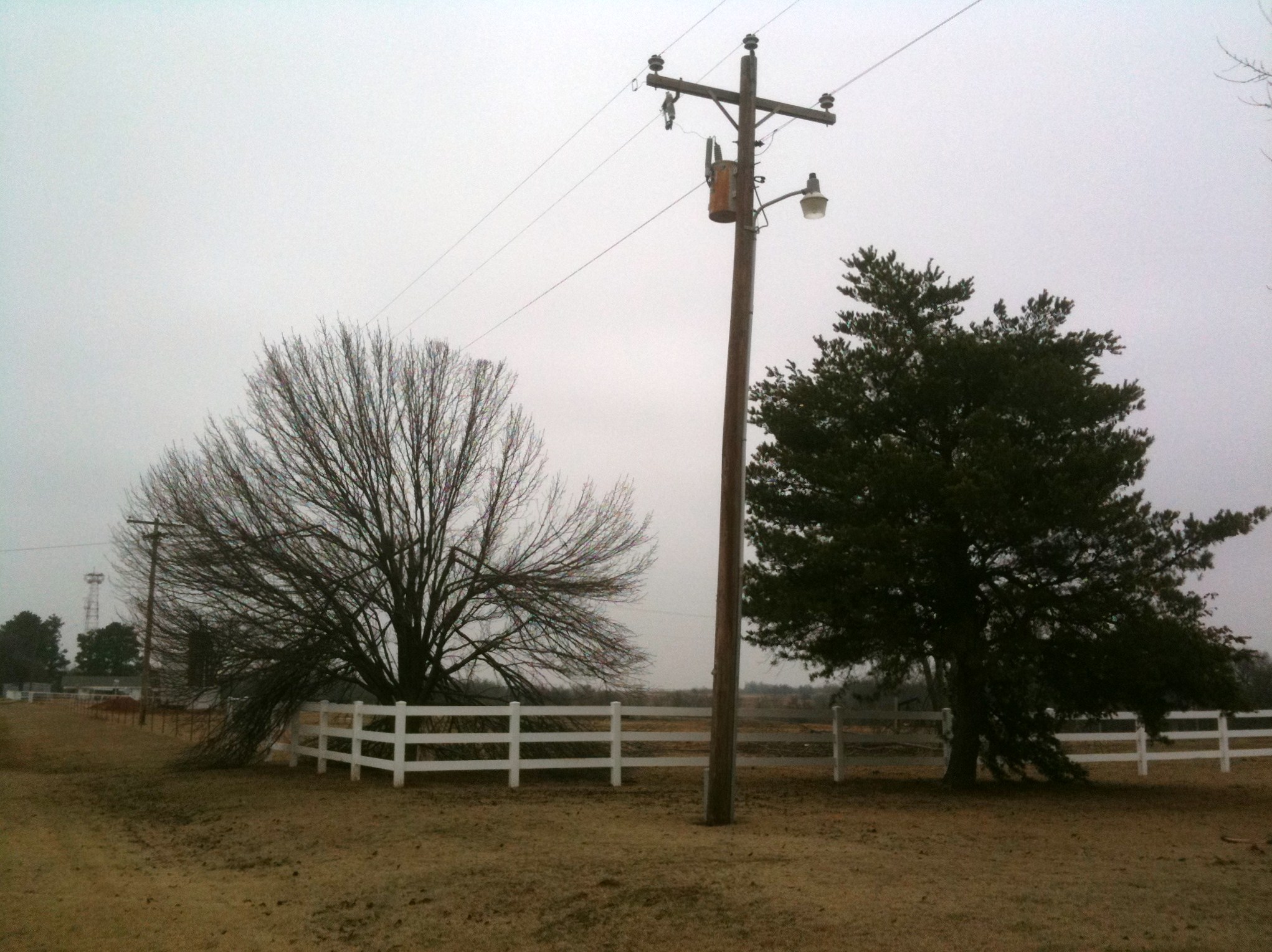 a utility pole and telephone box near a field