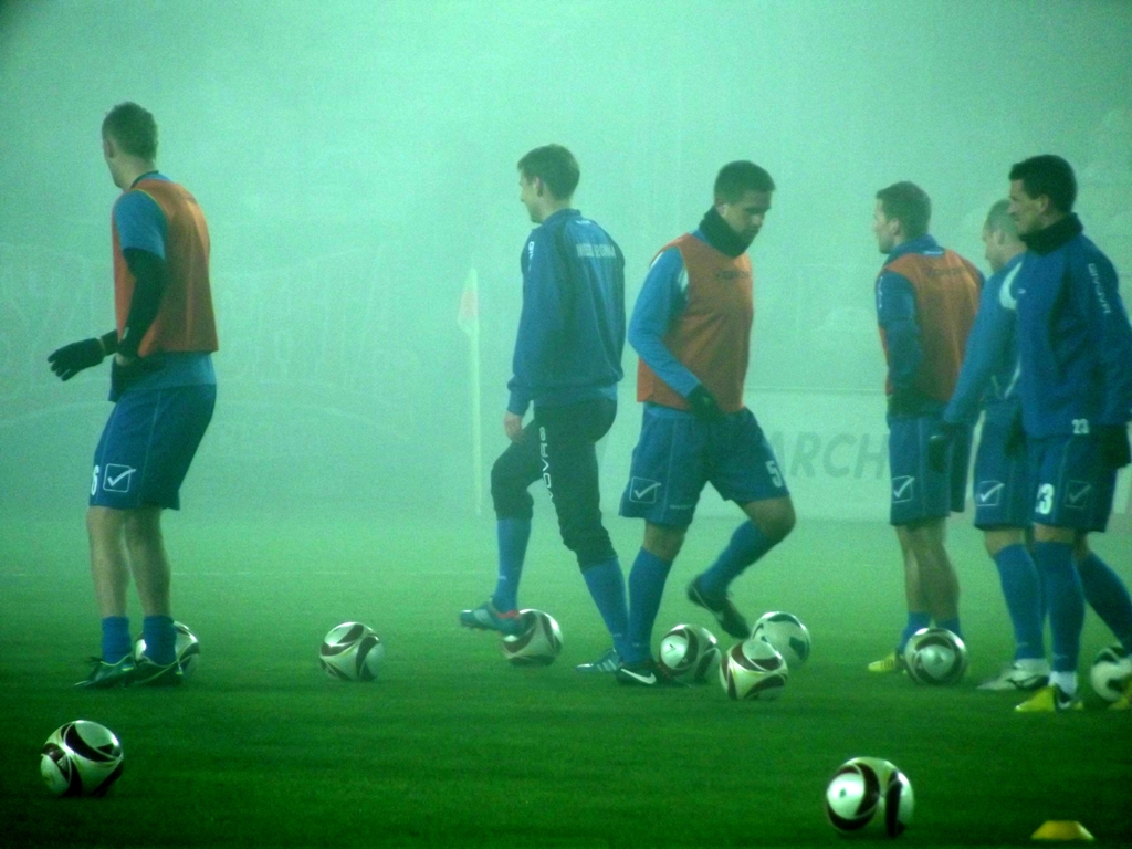 soccer players in action during a foggy practice session