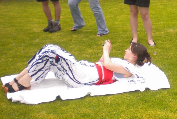 a woman laying on top of a towel in the grass