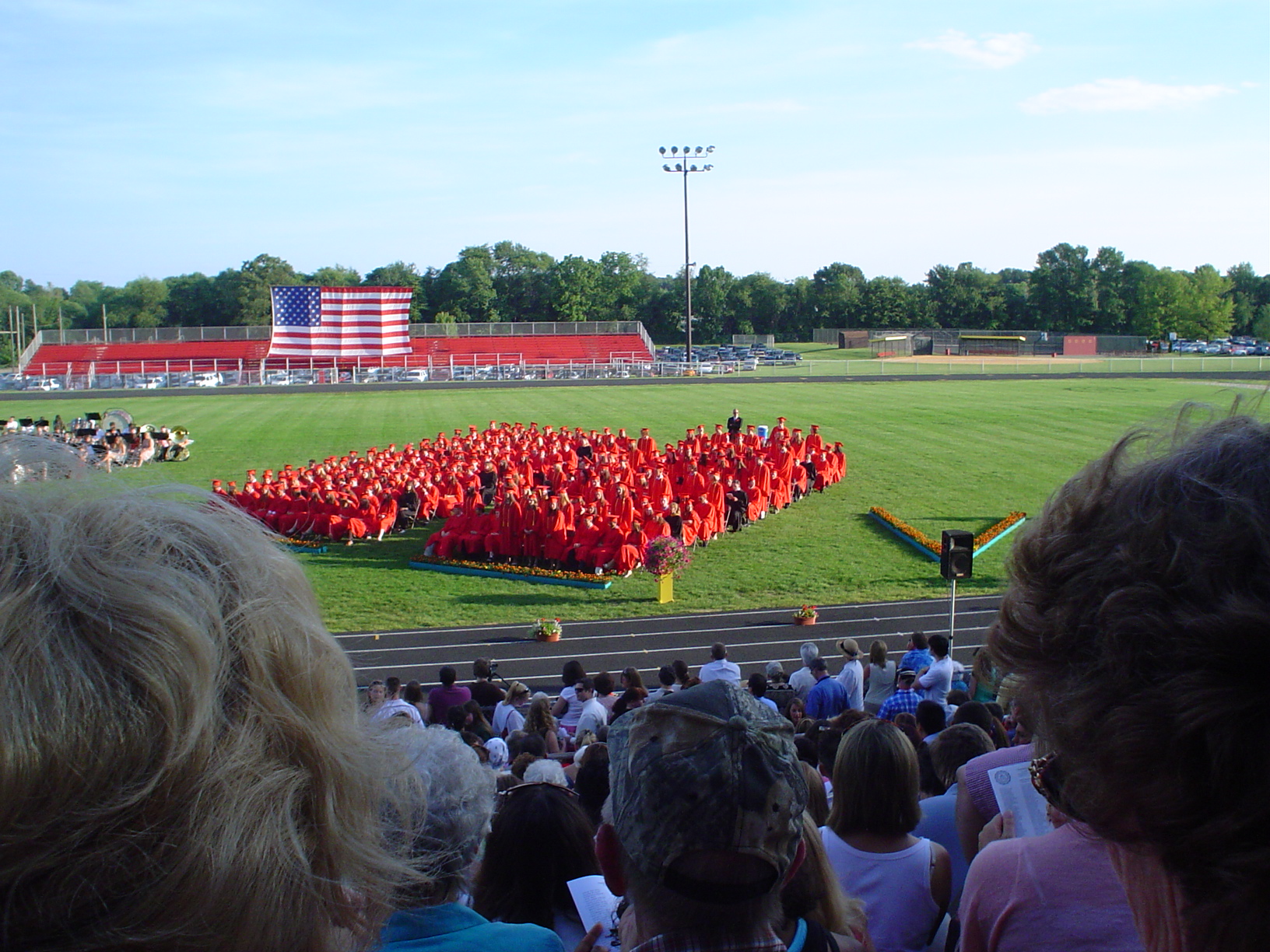 spectators watch as a large group of people stand at the ready