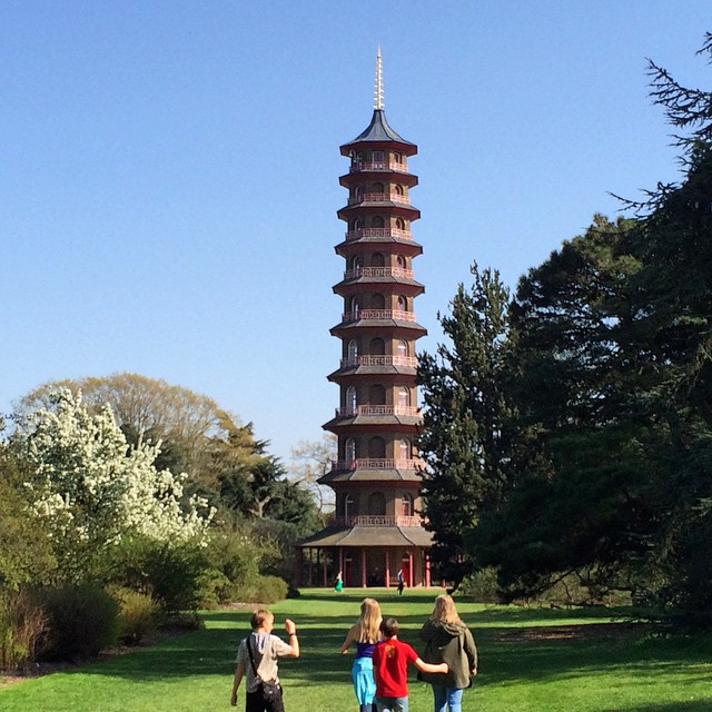 s walking around in front of a tall pagoda