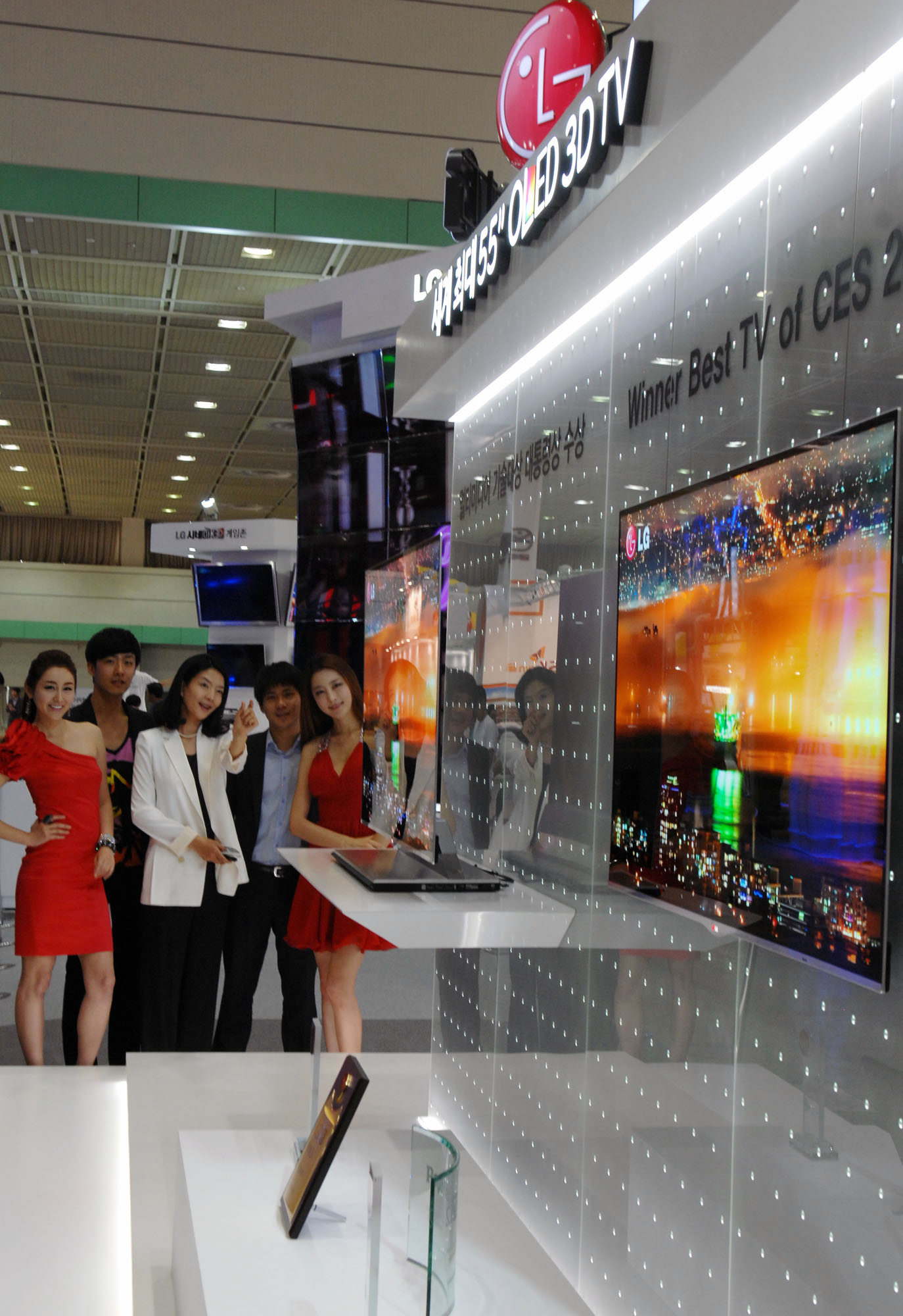 a group of people standing near a tv screen