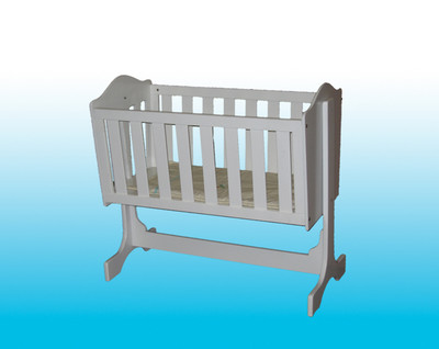 a toy crib on an aqua background is pictured
