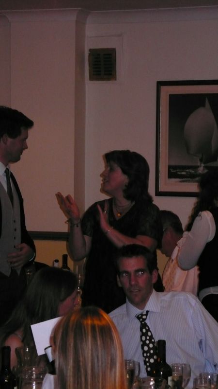 two people talking in front of a group of people