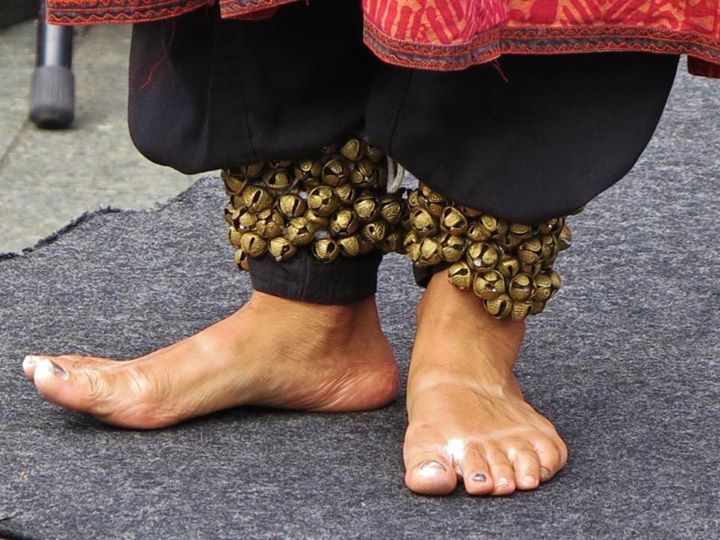 a woman's bare feet and shoes are covered in bead