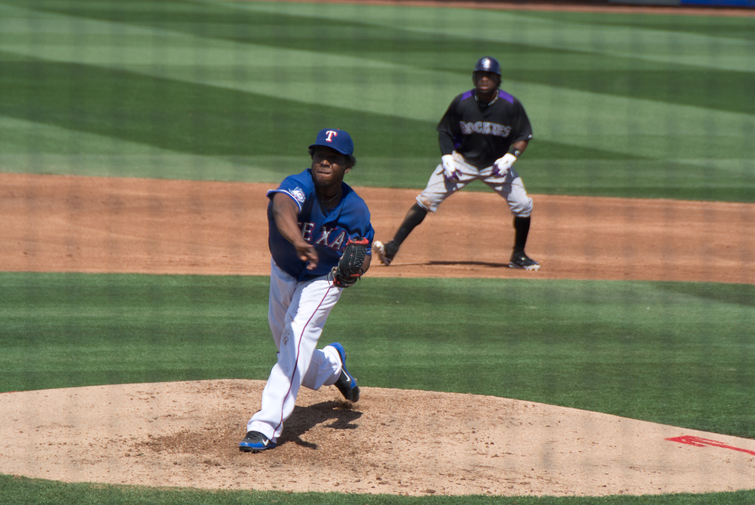 a baseball player pitching a baseball on a field