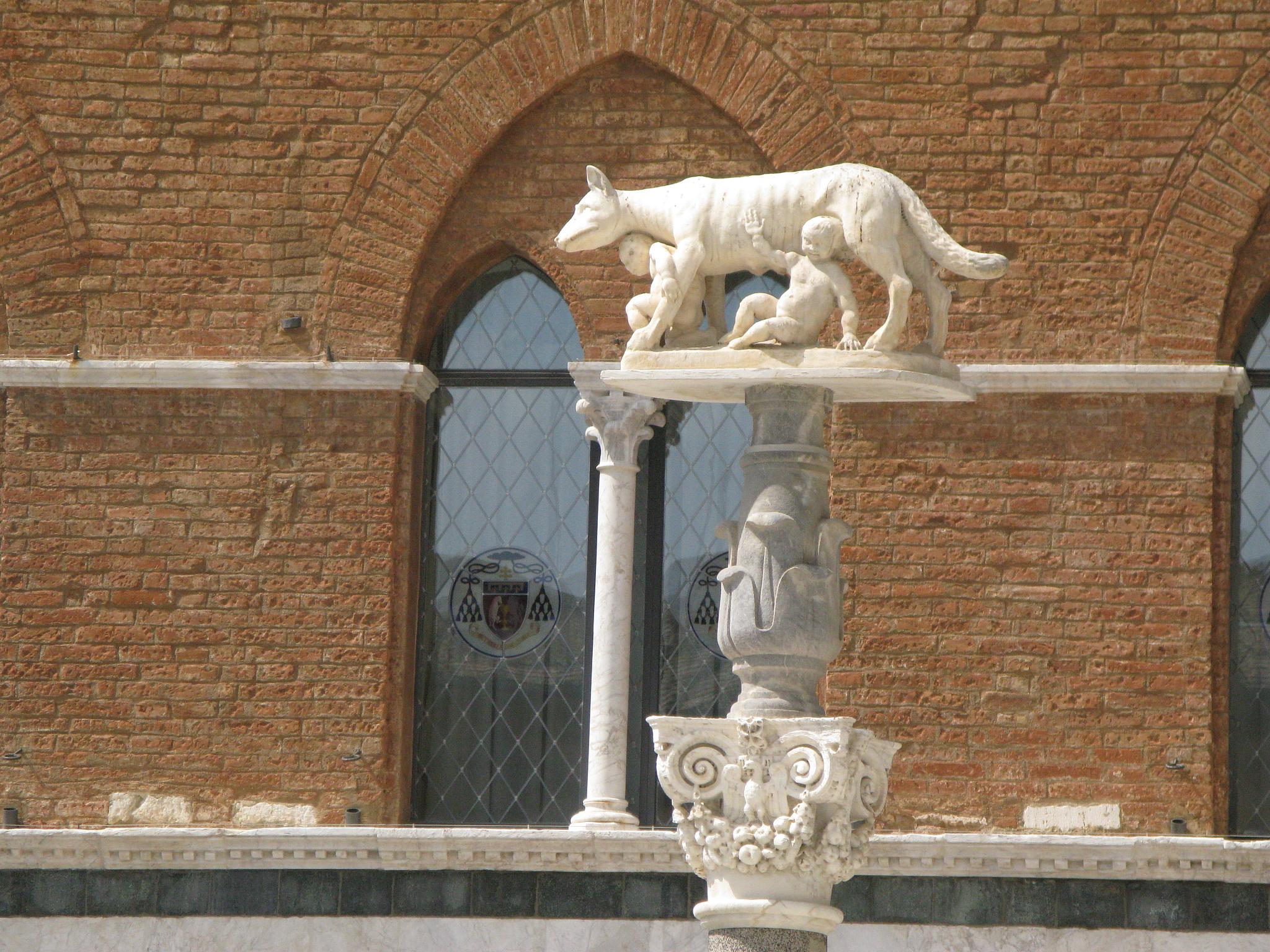 a white statue is standing in front of a large building