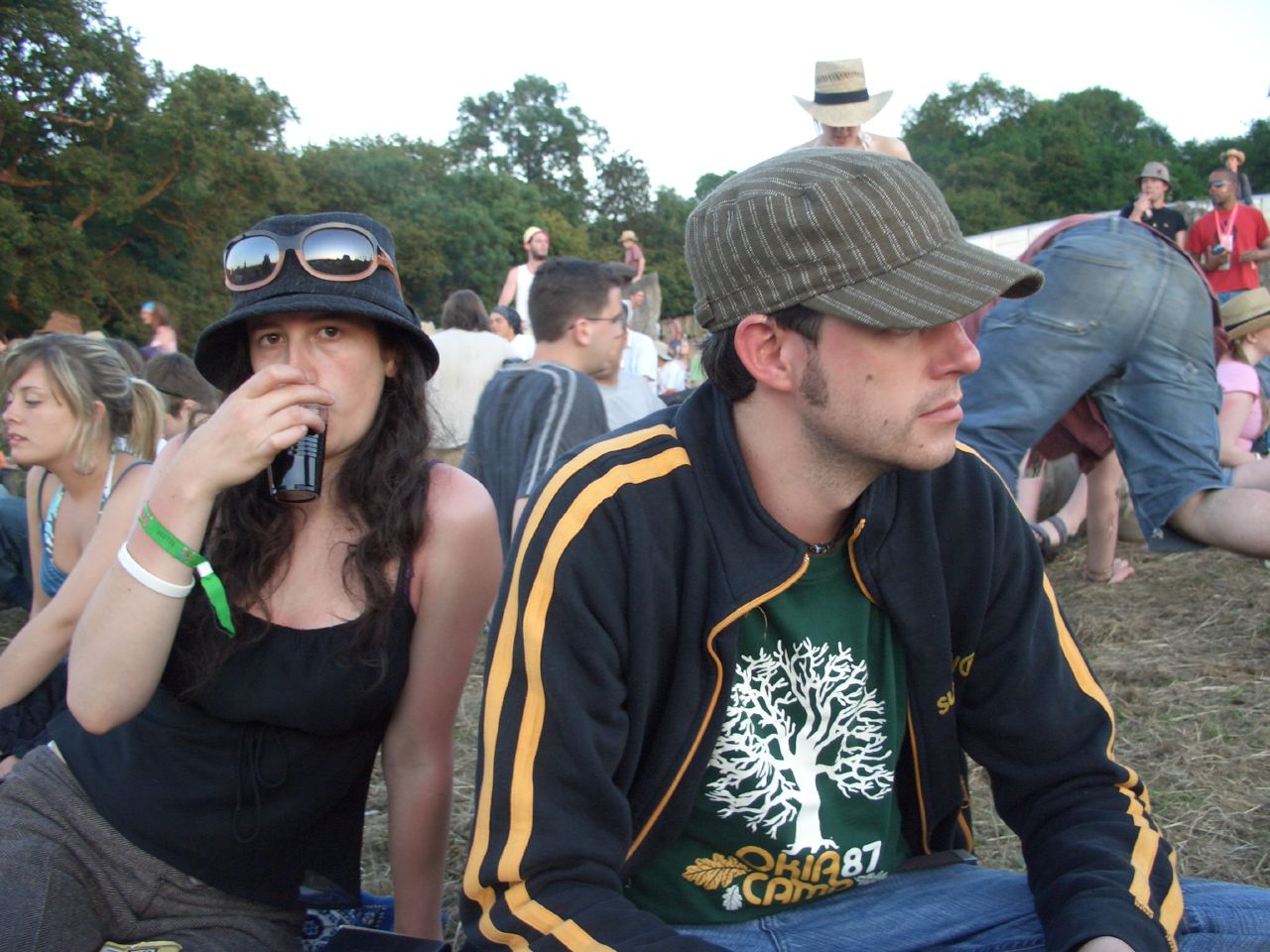 two people at a festival sitting and standing