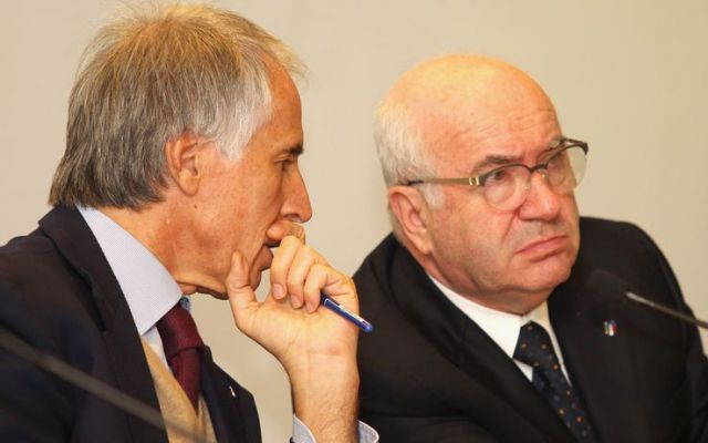 two men sitting next to each other at a meeting