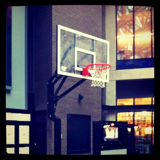 a basketball hoop on top of a building near a clock