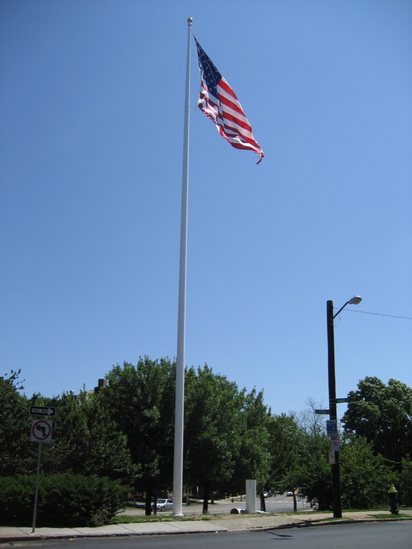 an american flag flying high over the street