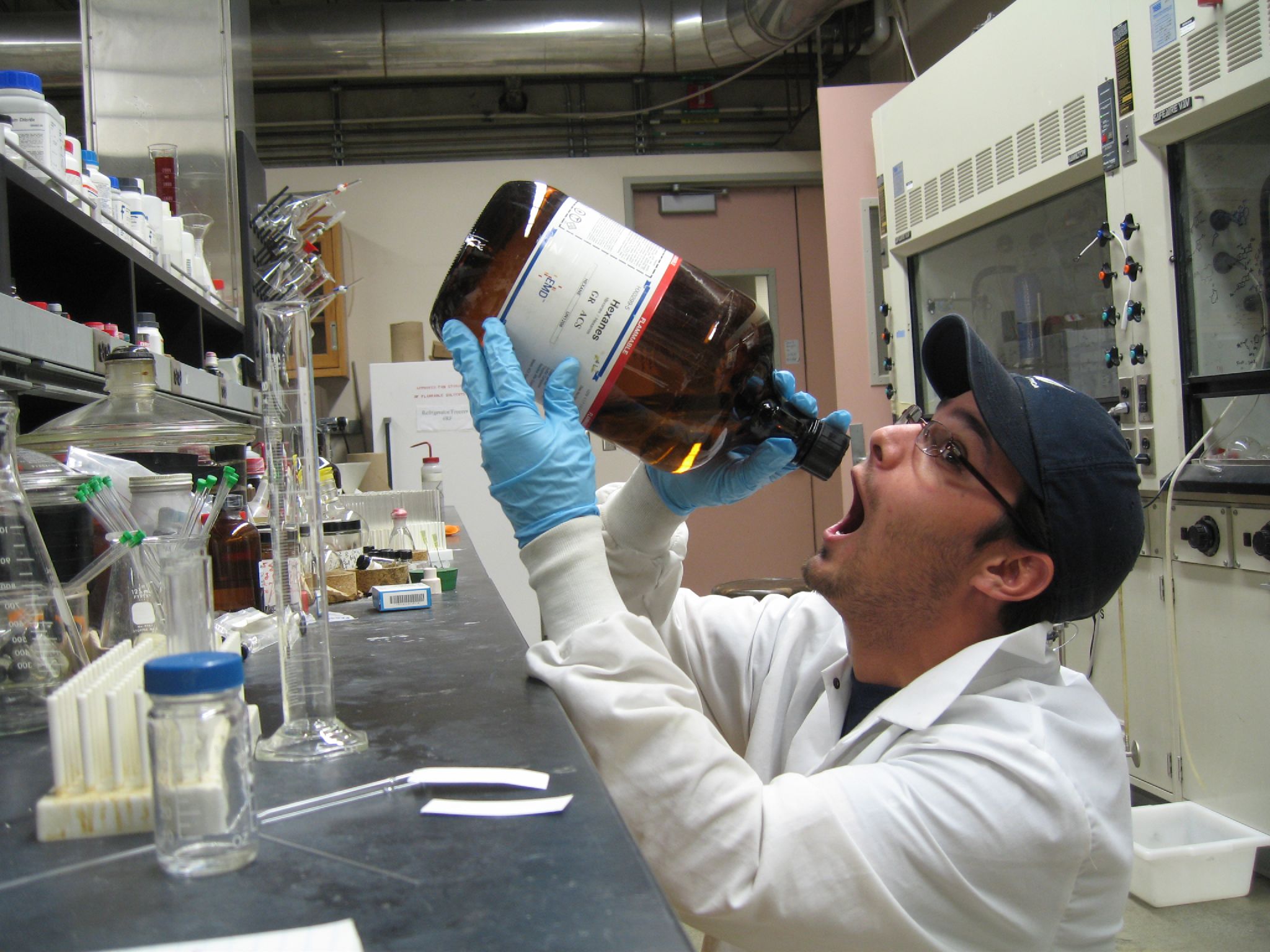 a man in a lab holding an empty bottle